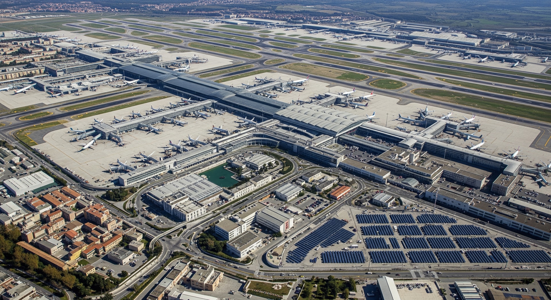 Aerial view of Rome Fiumicino Airport terminals and runways with solar installations