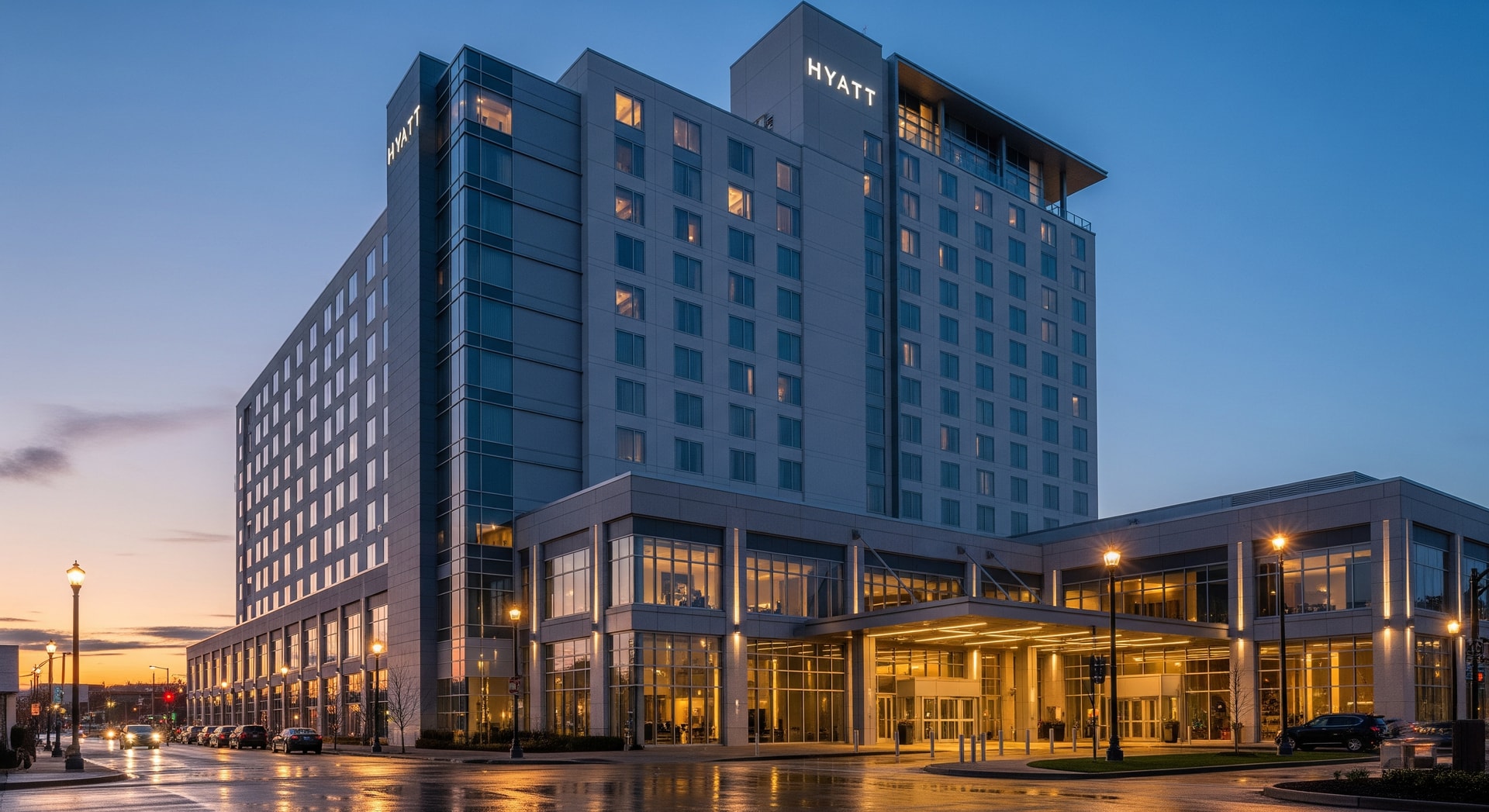 Exterior view of a Hyatt hotel at dusk with lit windows and signage