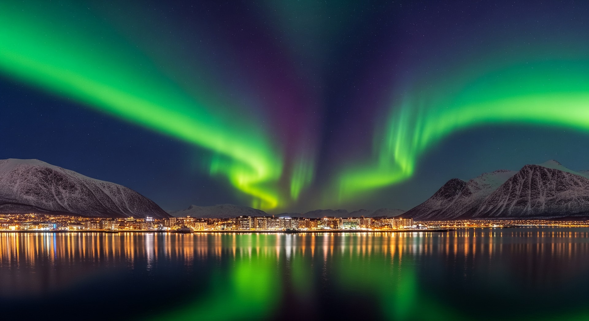 Aurora borealis over Tromsø's Arctic skyline with mountains and fjords